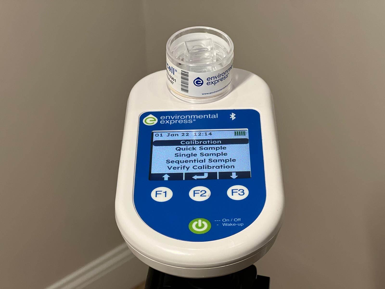 Handheld indoor air quality monitor showing sampling controls