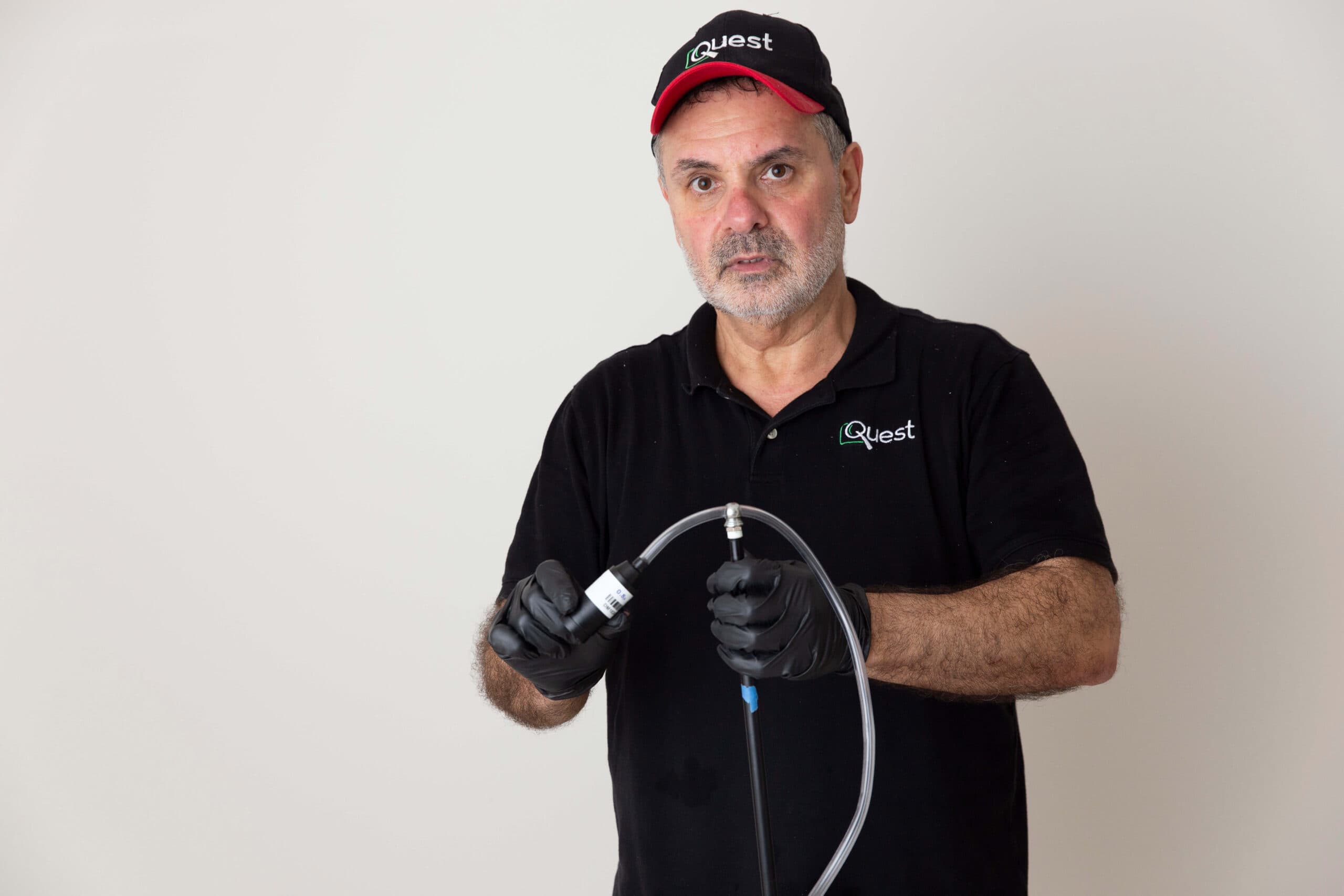 Quest team member holding a bulk air sampling hose and pump